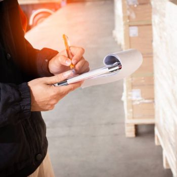 Hombre anotando información de un cargamento en una libreta