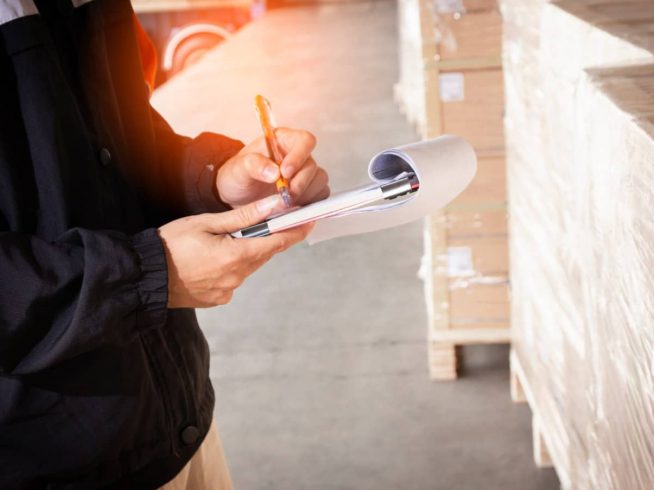 Hombre anotando información de un cargamento en una libreta