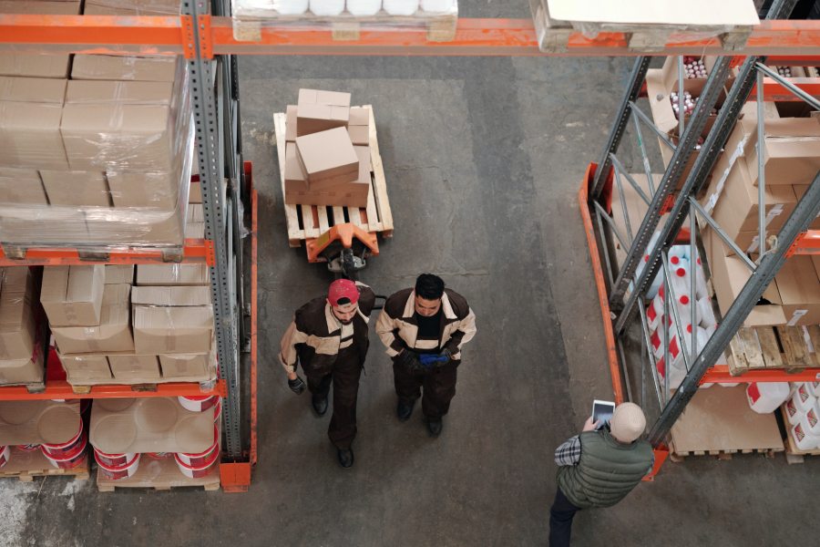Dos trabajadores dejando atrás productos para exportar adentro de almacén